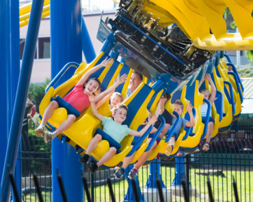 Children riding yellow and blue suspended roller coaster